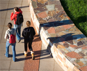 Students walking alongside of new stone wall